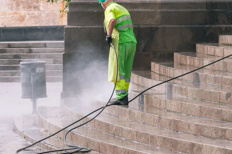 Operative pressure washing a concrete surface with a high pressure lance before it is resealed